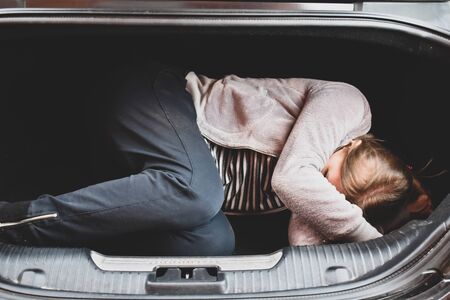 Victim lies in the trunk. The car is a crime. Captive in the carの写真素材