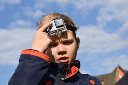 Child shoots video autdoor. The camera on the foreheadのeditorial素材