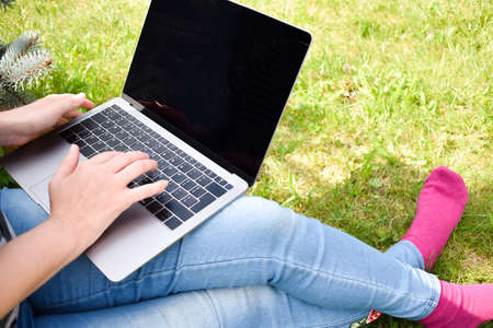 child girl is studying remotely. Distance education. A kid with a laptop outside. Home schooling