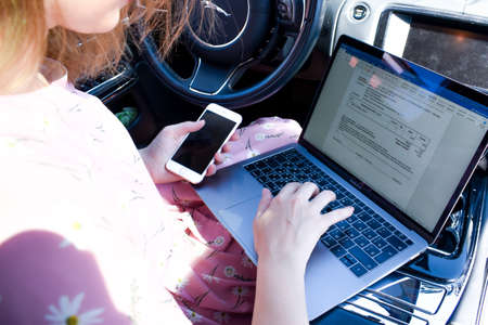 Work in the journey. Professional woman inside an expensive car. Working environment.のeditorial素材