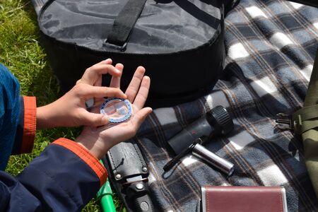 compass in the hand of a child traveler. Orienteering. Hiker boy going camping.