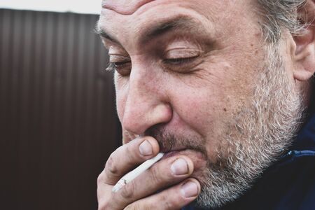 the harmfulness of cigarette Smoking. smelly tobacco smoke. A man smokesの写真素材