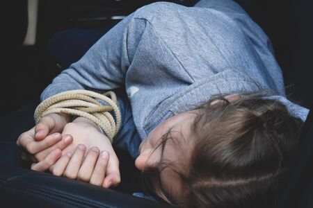 ropes on the hands of little victim girl. Violence against children. Kidnappingの写真素材