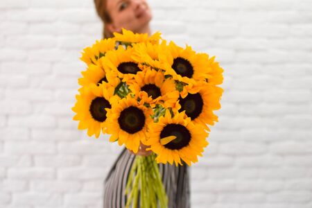 a large bouquet of yellow sunflowers in the hands insideの写真素材