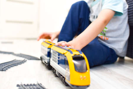child playing with toy plastic train on the floor in kindergartenの写真素材