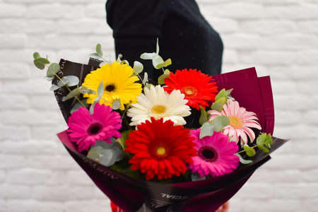 beautiful girl with a bouquet of flowers in hands. fresh flowers delivery. girl sniffing flowersの写真素材