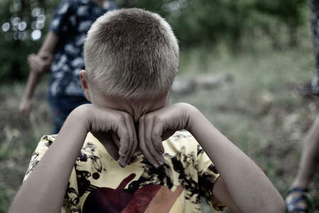 child bullying. humiliation of teenager. Boy crying outdor. Childhood aggression and cruelty. child street mental traumaの写真素材