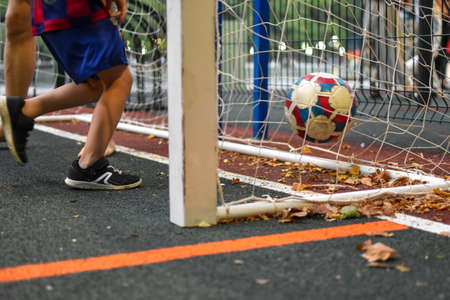 boy plays football with father on outdoor playing field. children's sport hobby with a ball. the child is practicing playing footballの写真素材
