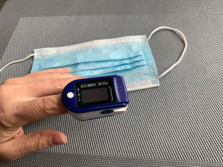 measuring the level of oxygen in the blood. a device for measuring the level of saturation with covid. Symptoms of the disease with the covid-19 virus.のeditorial素材
