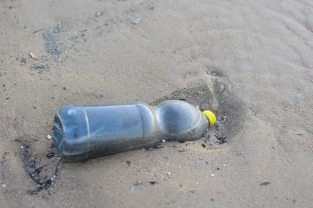plastic bottle on the sand by the sea. environmental pollution. life without plastic