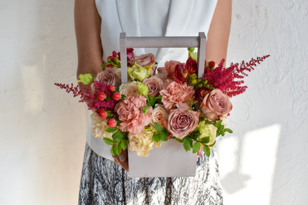 Woman with a bouquet of flowers. Beautiful flowers for the holiday. Woman with beautiful flowers in her hands indoors background. A bouquet of flowers for a flower shop.の写真素材
