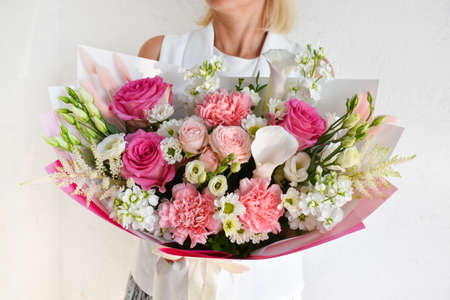 beautiful bouquet of flowers in the hands of a woman. photo for postcard and catalog of an online flower shop. fresh flower deliveryの写真素材