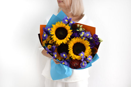 beautiful bouquet of flowers in the hands of a woman. photo for postcard and catalog of an online flower shop. fresh flower deliveryの写真素材