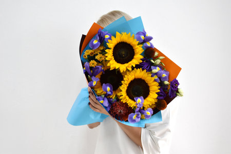 beautiful bouquet of flowers in the hands of a woman. photo for postcard and catalog of an online flower shop. fresh flower deliveryの写真素材