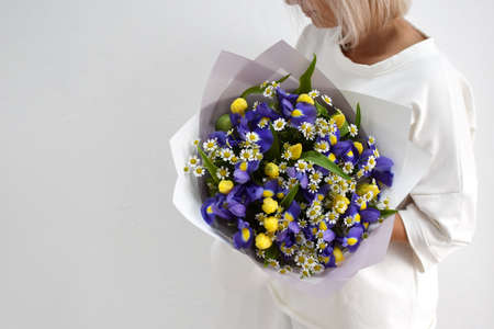 beautiful bouquet of flowers in the hands of a woman. photo for a postcard and catalog of an online flower shop. fresh flower deliveryの写真素材