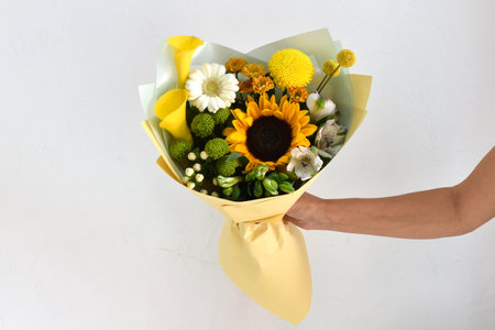Woman with a bouquet of flowers. Beautiful flowers for the holiday. Woman with beautiful flowers in her hands indoors background. A bouquet of flowers for a flower shop.の写真素材