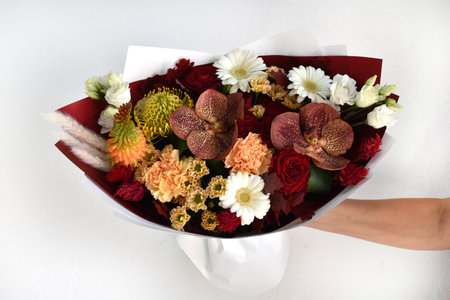 Woman with a bouquet of flowers. Beautiful flowers for the holiday. Woman with beautiful flowers in her hands indoors background. A bouquet of flowers for a flower shop.の写真素材