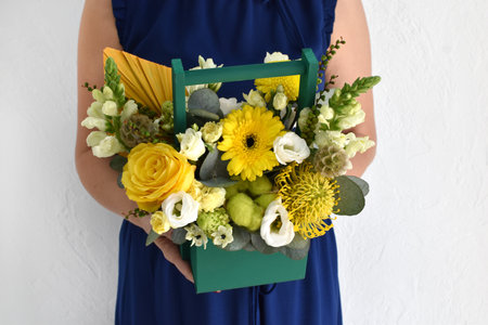 Woman with a bouquet of flowers. Beautiful flowers for the holiday. Woman with beautiful flowers in her hands indoors background. A bouquet of flowers for a flower shop.の写真素材