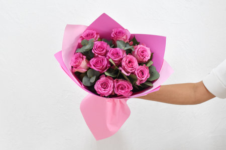 Woman with a bouquet of flowers. Beautiful flowers for the holiday. Woman with beautiful flowers in her hands indoors background. A bouquet of flowers for a flower shop.の写真素材