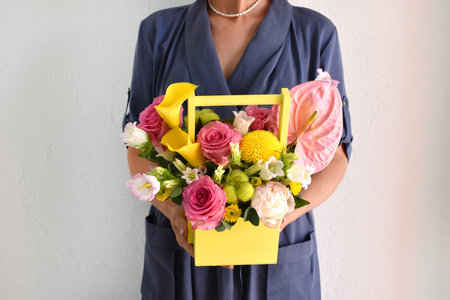 flowers in a hat box. woman with a bouquet of flowers. online catalog of flower delivery shop. plant bloom compositionの写真素材