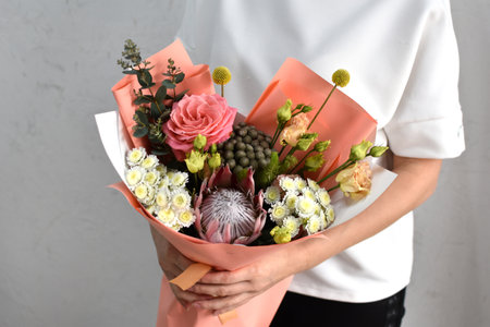 woman with bouquet of flowers. Beautiful flowers for holiday. Woman with beautiful flowers in hands indoors background. bouquet of flowers for flower shop.の写真素材