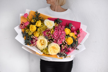 woman with bouquet of flowers. Beautiful flowers for holiday. Woman with beautiful flowers in hands indoors background. bouquet of flowers for flower shop.の写真素材