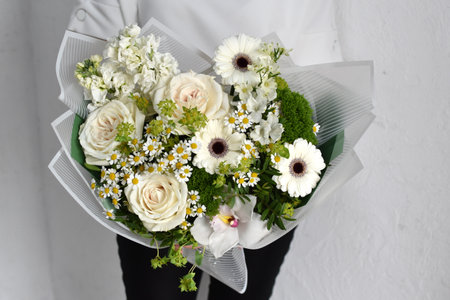 woman with bouquet of flowers. Beautiful flowers for holiday. Woman with beautiful flowers in hands indoors background. bouquet of flowers for flower shop.の写真素材