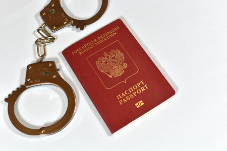 Russian passport and handcuffs on a white background. prohibition of Russian citizens on entry and exit. passport lockの写真素材