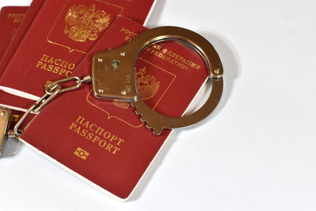 Russian passport and handcuffs on a white background. prohibition of Russian citizens on entry and exit. passport lockの写真素材