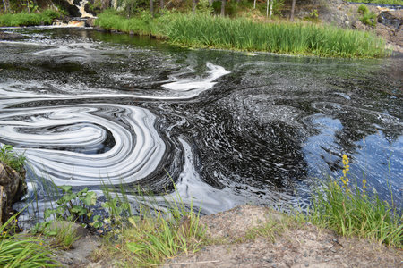 dirty contaminated water in the lake. toxic oily stain on the surface of the water.の写真素材