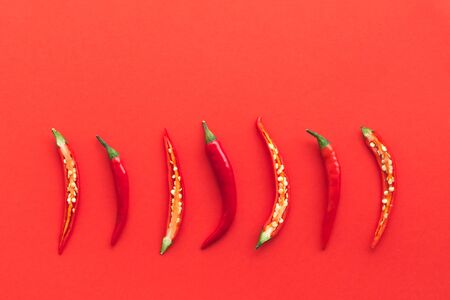Fresh hot chili peppers on a red background. Flat lay style.の写真素材