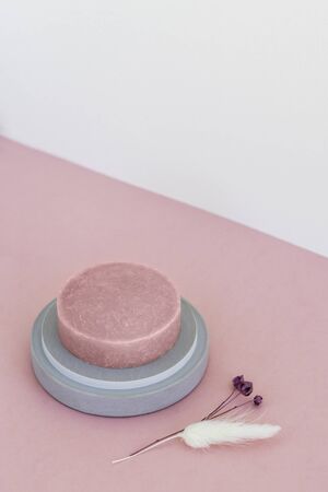 Round pink moisturizing soap in a concrete soap dish on pinkの写真素材
