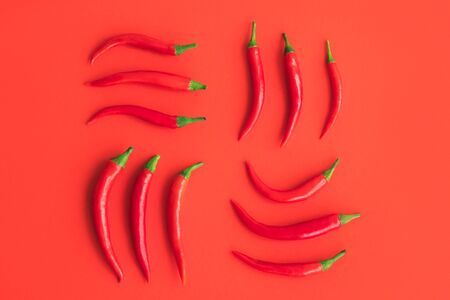 Fresh hot chili peppers on a red background. Flat lay style.の写真素材