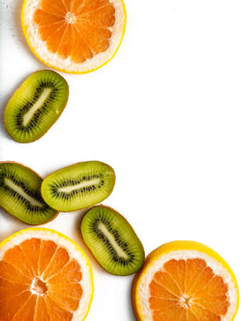 Sliced grapefruit half isolated on black background. Pink,orange Fresh grapefruit citrus fruit, slice with zest, dramatic light texture, colorful sliced fruits as background back lighted, copy spaceの写真素材