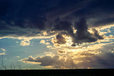 Skyscape cloudscape colorful dark orange blue sky clouds at evening sunsetの写真素材