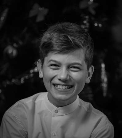 Beautiful handsom young man wearing WHITE SHIRT, Closeup portrait of young man BEIGE CHRISTMAS TREE background, Attractive teenager. caucasian SMILE FUN HAPPYの写真素材