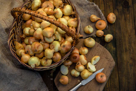 Fresh Red onion in basket on wooden table, top view, Organic food brown slices, still life rustic raw cutting board outside wicker basket Bulb Food Ingredients local farmers market storeの写真素材