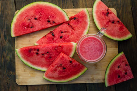 Delicious watermelon outdoors wooden table, GREEN natural background Slice sunny day, Heap, Fresh...