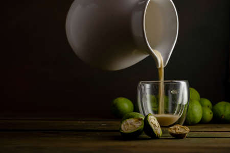 green walnut kernels leaves wooden table oil nuts unripe husks healthy food drink, old rustic table Background Harvest, organic Homemade plant based milk Dairy free jug glass cupの写真素材