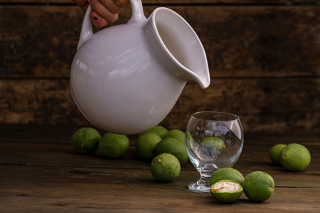 green walnut kernels leaves wooden table oil nuts unripe husks healthy food drink, old rustic table Background Harvest, organic Homemade plant based milk Dairy free jug glass cupの写真素材