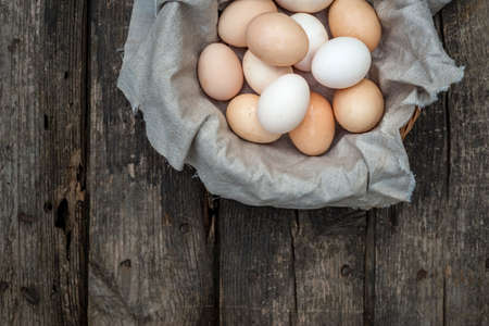 fresh natural organic eggs wooden table background Food Rustic Still Life sack bag wicker basket chicken feathers linen napkin countryside Investment Concept easter space text Top view heyの写真素材