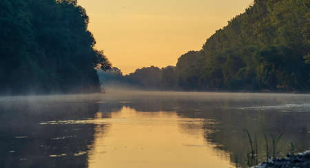 early morning river. fog trees. sunlight mist water. Olanesti Moldova Dniester river reflection, beautiful summer landscape sunrise quiet fishing spot forestの写真素材