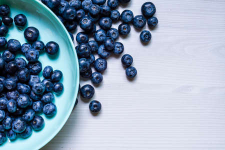 Fresh Blueberries blueberry BowlTable Freshly picked turquoise bowl. Juicy and fresh blueberries Bilberry white wood food Background. antioxidant. Concept healthy eating nutrition fruit top view.の写真素材