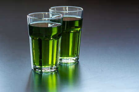 Lemon mint iced green tea cocktail refreshing drink for summer days two glass herbal dark backgroundの写真素材