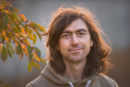 close-up man portrait long hair, easy bristle attractive Handsome outdoors Sour Cherry leaves...