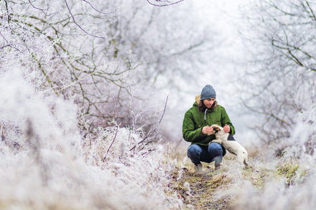 beautiful winter landscape with man playing dog background with snow covered trees Ð¡hristmas hoarfrost Snow path dry grass White Alley background Moldovaの写真素材