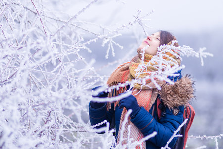 girl portrait Conception of winter holidays. park Cheerful girl in warm orange clothes playing with...