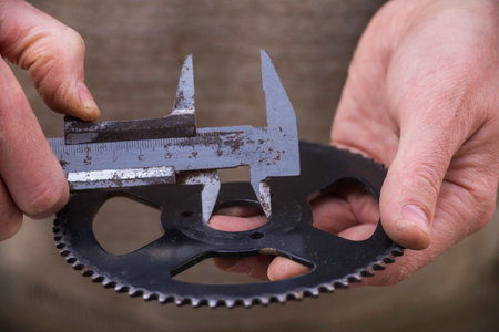 metal shtangel bar circulates Auto mechanical carefully measures the desired part The worker is...