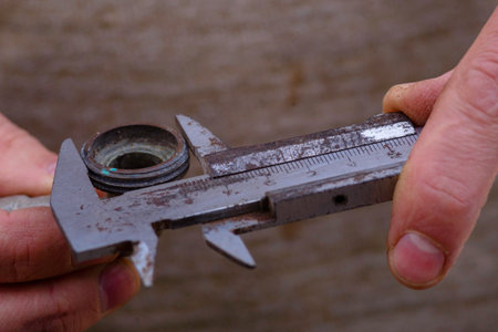 metal shtangel bar circulates Auto mechanical carefully measures the desired part The worker is measuring to inner diameter of flange with vernier caliper gauge Pipe Men's Hands Holdingの写真素材