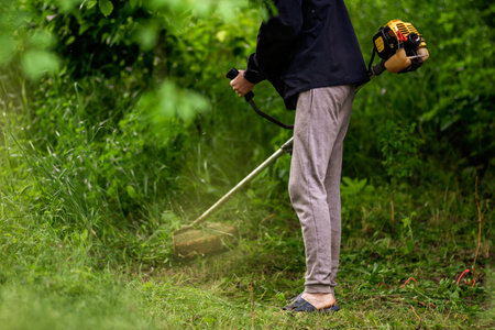 Caucasian Gardener working man Manual hand grass cutter Weed Cutter or Power Weeder or Brush Cutter...